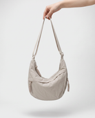 all-groups - The Agathe Crossbody, held by the strap, showing how light it is at 180 g