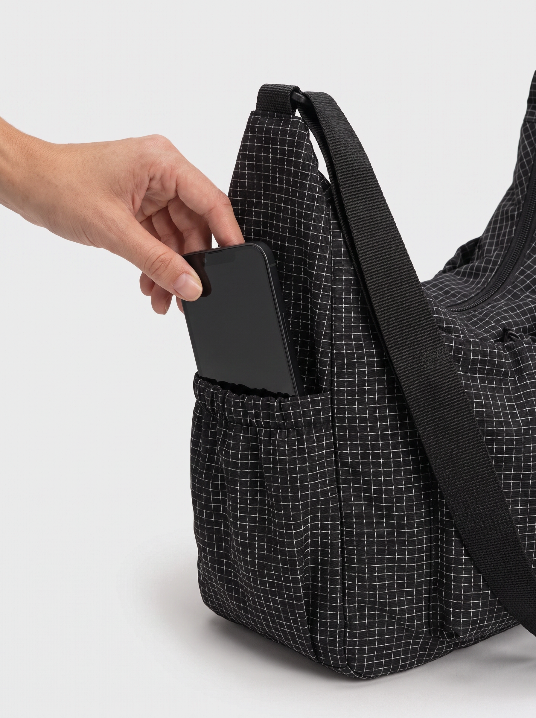 all-groups - The Lucienne Crossbody, side pocket holding a phone